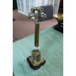 A Victorian brass and iron doorstop of tall fluted form with foliate handle,