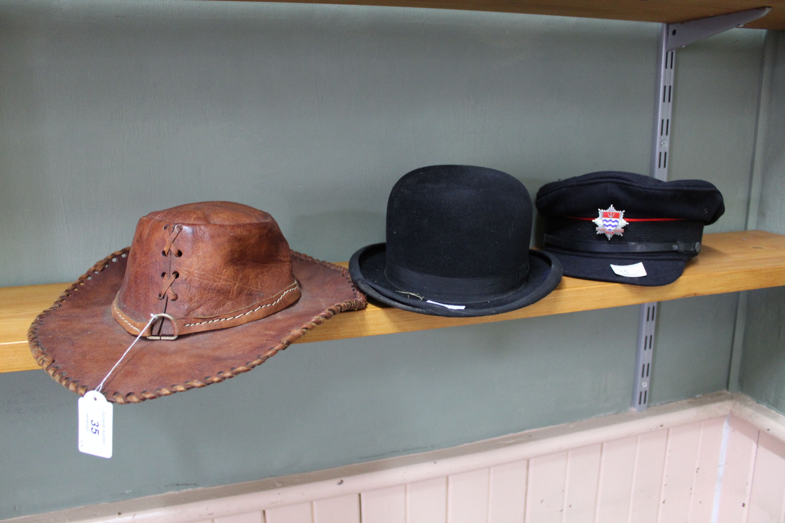 A London Fire Brigade hat plus a bowler and brown leather Australian style hat