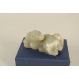 A Chinese Celadon jade carving of a recumbent dog,