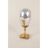 A 20th Century Russian plated egg on brass stand,