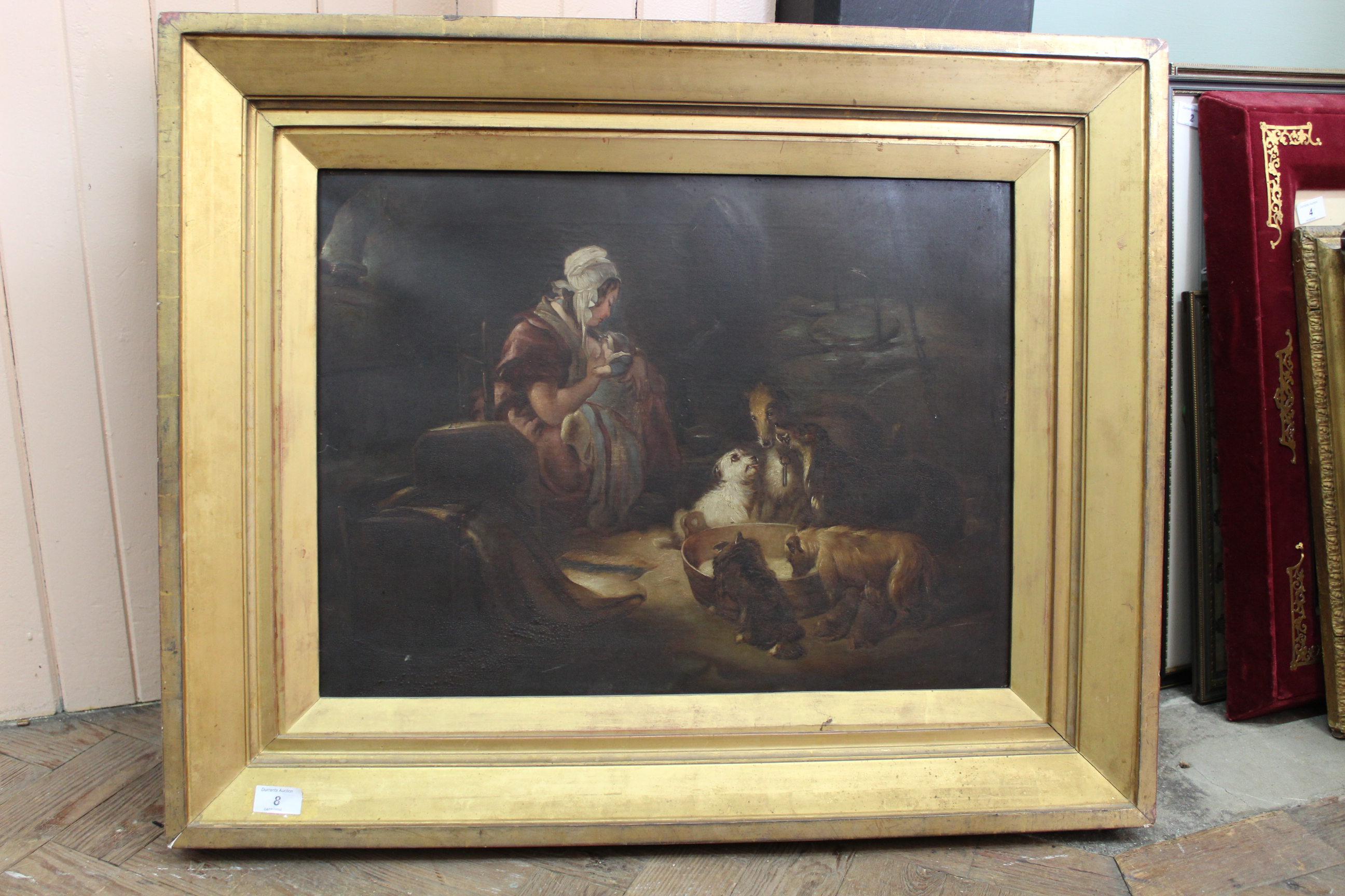 A late 19th Century oil on canvas of a cottage interior with mother and baby and dogs drinking from