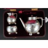 A Victorian silver three piece bachelors tea set with engraved floral decoration on ball feet,