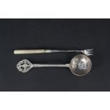 A large silver sifting spoon with engraved decoration,