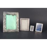 A collection of photograph frames including white metal dragon design together with three silver