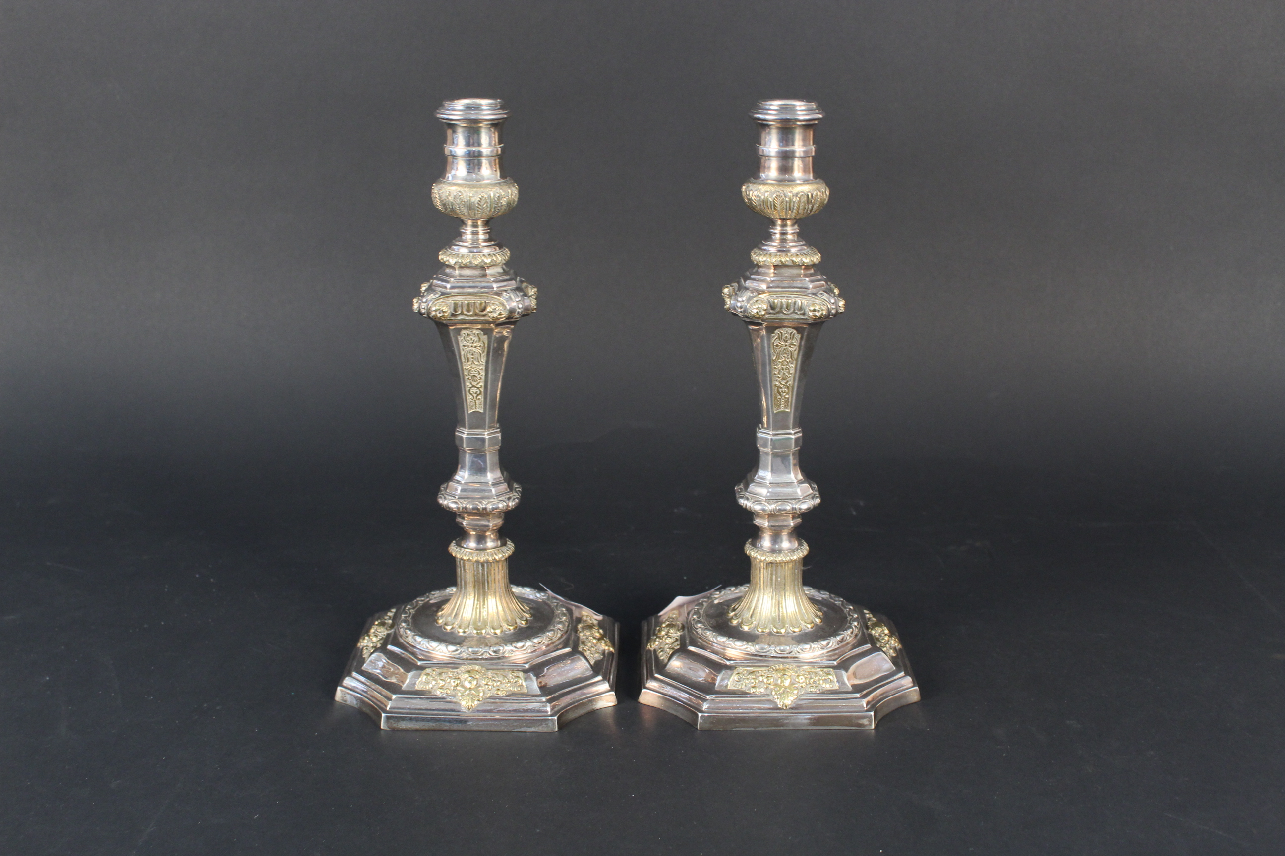 A pair of silver candlesticks with gilt floral and cherub decoration,