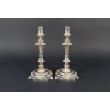 A pair of silver candlesticks with gilt floral and cherub decoration,