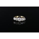 An impressive five stone diamond ring, the graduating old cut diamonds claw mounted in white metal,