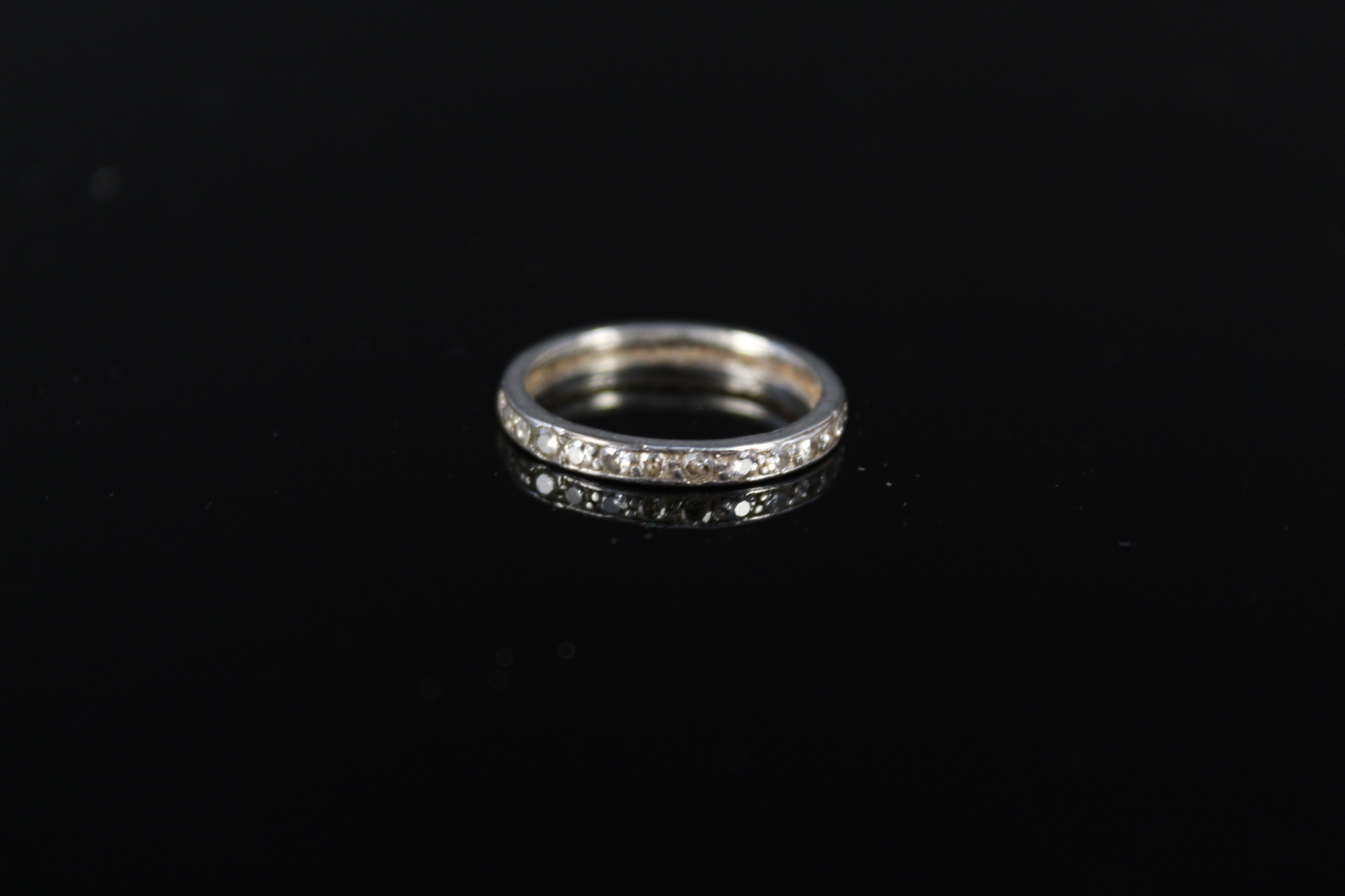 A white metal diamond set eternity ring, size J 1/2, approx 1.