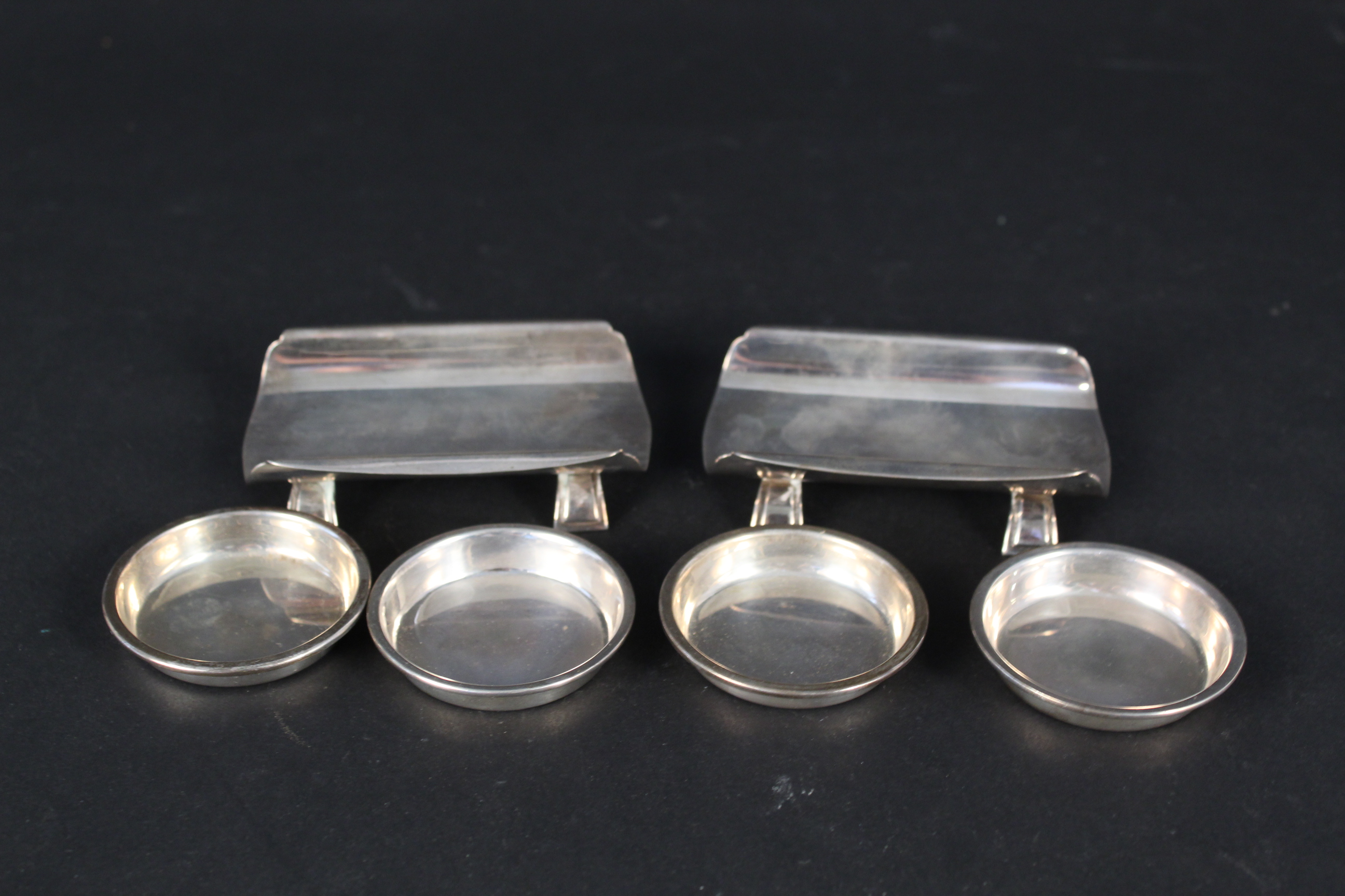 A pair of Art Deco silver knife rests, Birmingham 1934 together with four silver spoons rests,