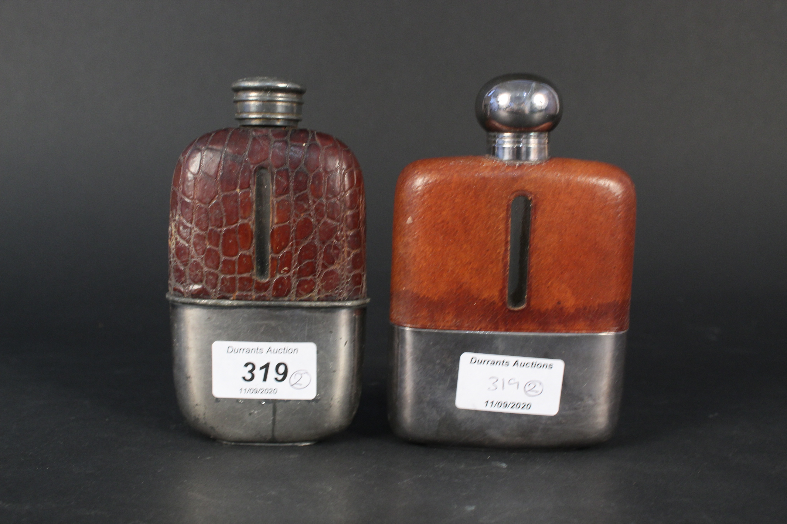 Two glass hip flasks with detachable silver plated cups