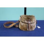 A deer skin cartridge bag with leather trim and carrying strap