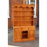 A pine kitchen dresser with shelved top