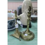 A large antique Dutch brass candlestick with circular drip tray,