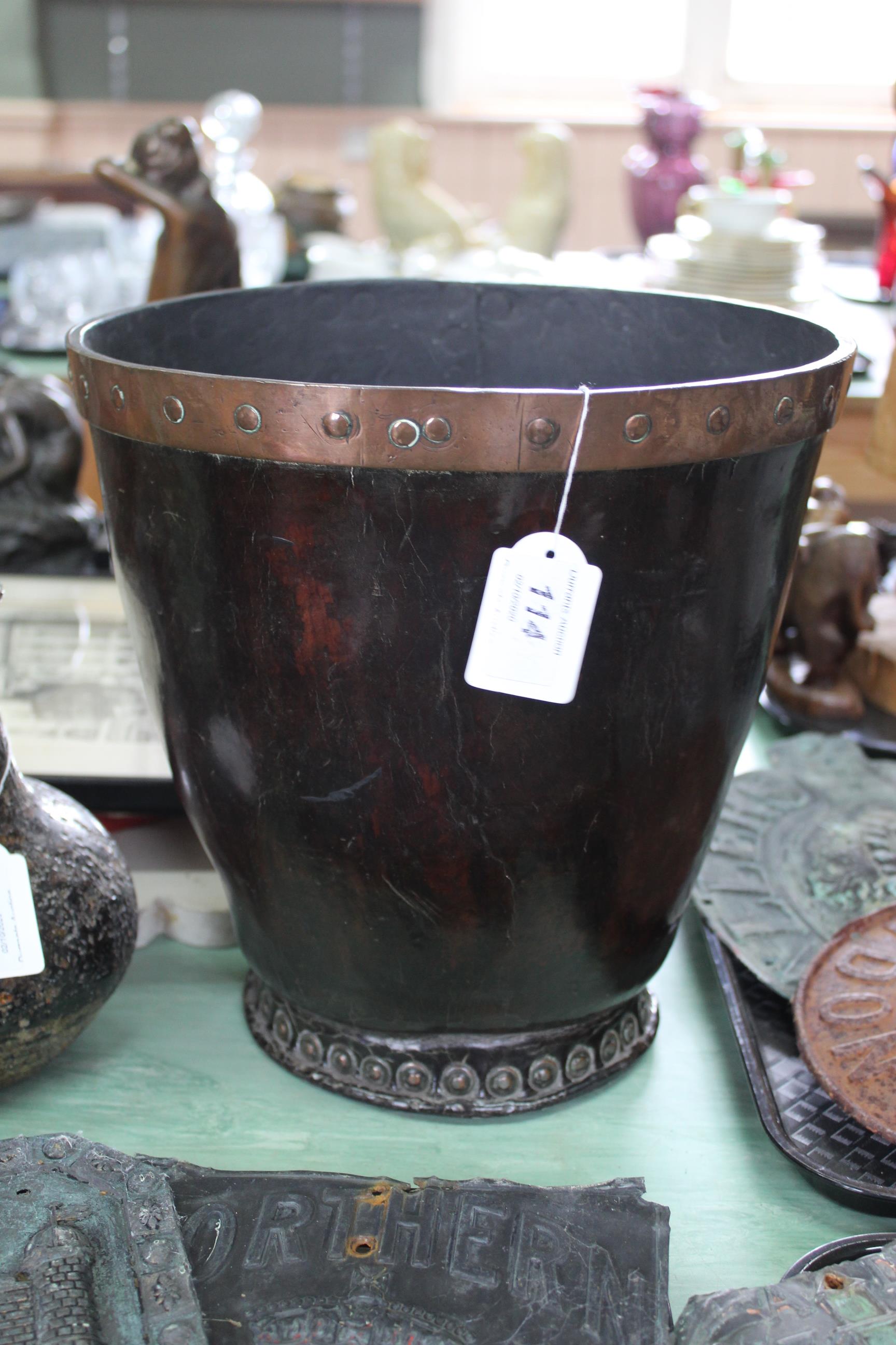 A George III leather bucket of fine original patina with riveted copper rim,