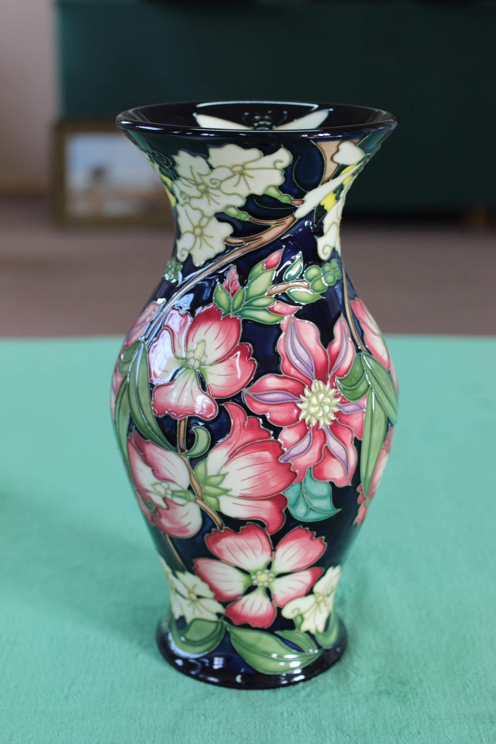 A Moorcroft scarce vase decorated with clematis and jasmine flowers with bee on the lip,