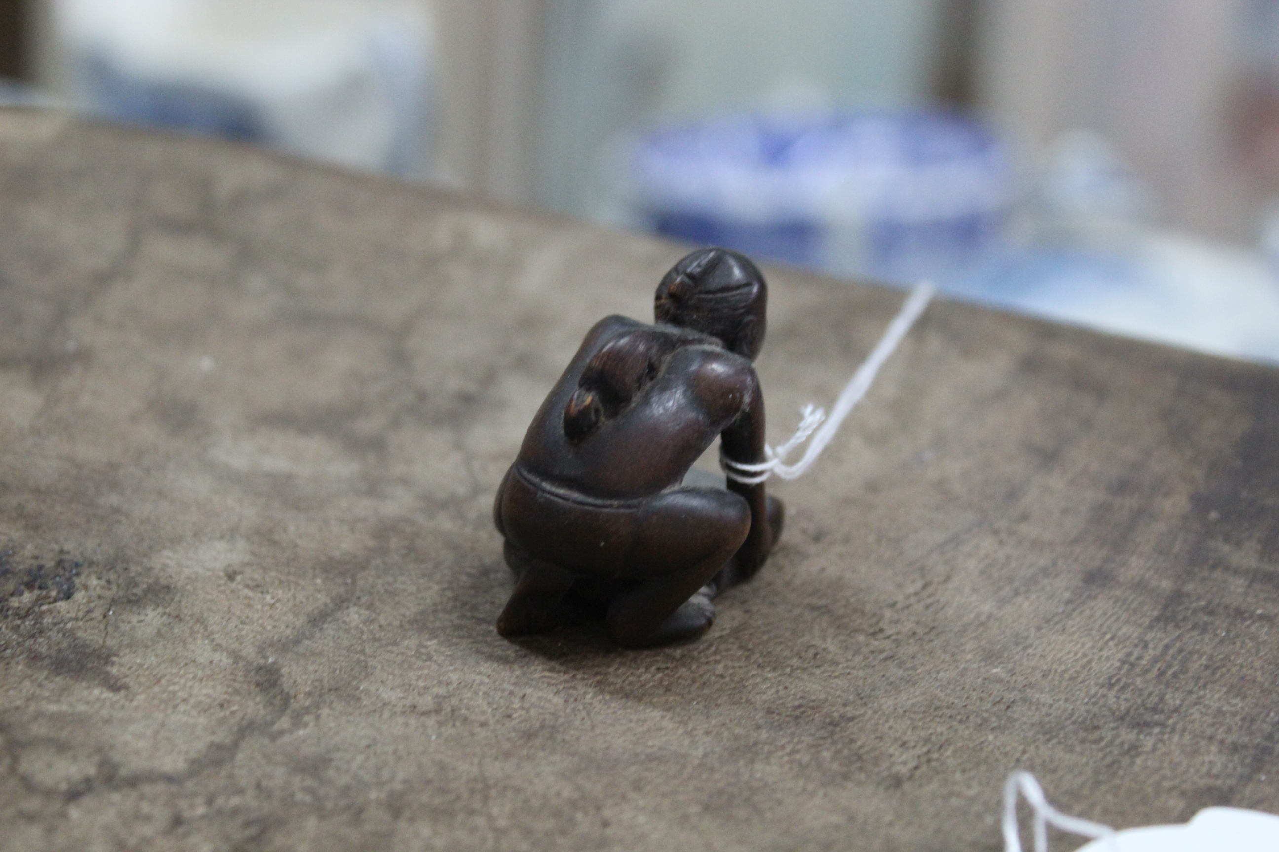 An antique carved wood netsuke of a kneeling figure of a man with a rat on his back, - Image 2 of 3