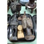 A tray with a selection of six carved wood items including a four faced man, tribal woman,