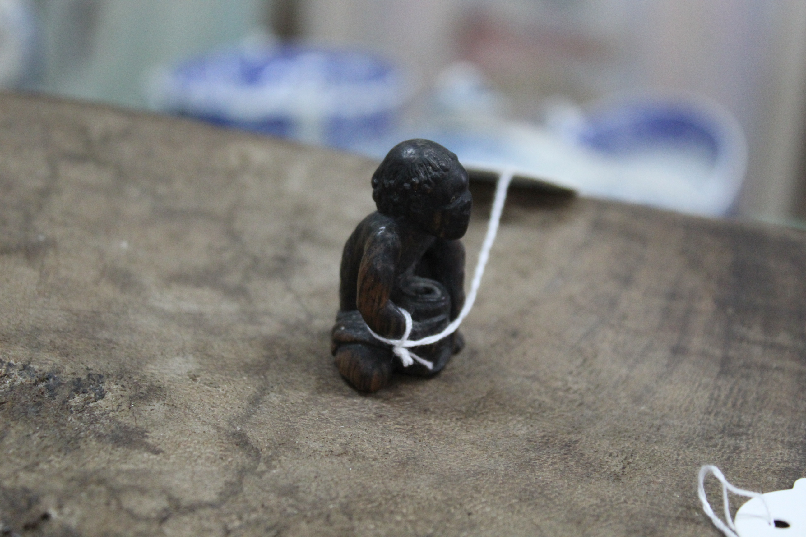 An antique carved wood netsuke on an emaciated man with pot, inset metal eyes, not signed, - Image 3 of 3