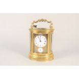A Victorian heavily engraved brass oval carriage clock dated 1865, chiming with alarm,