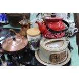 A tray of kitchen items including a pottery cheese dish, plated gong on stand,