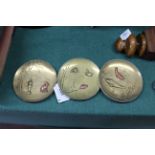 A set of three brass and copper oriental dishes with fish,