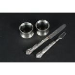 A pair of silver napkin rings and a Victorian silver christening knife and fork (handles as found)