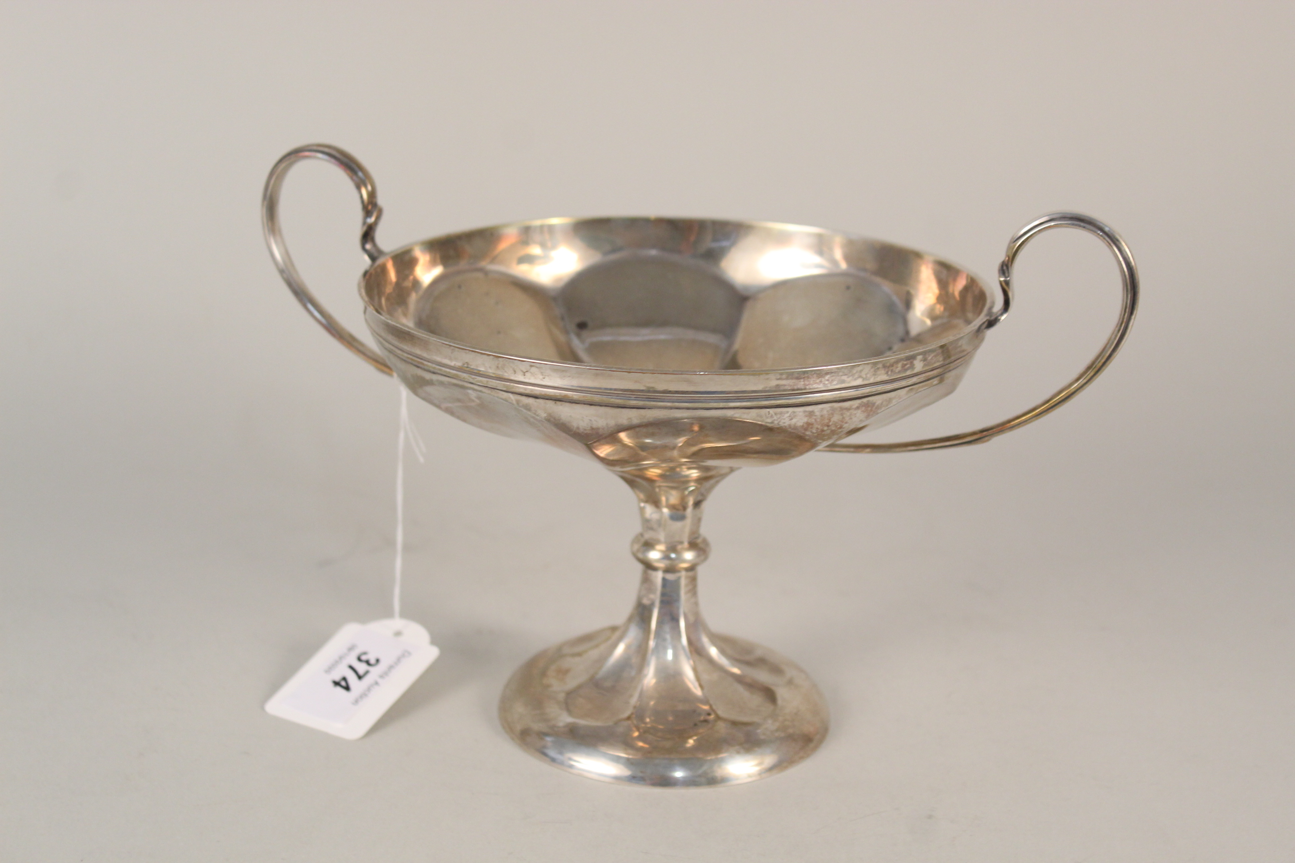 A silver twin handled sweetmeat dish on pedestal base (as found),