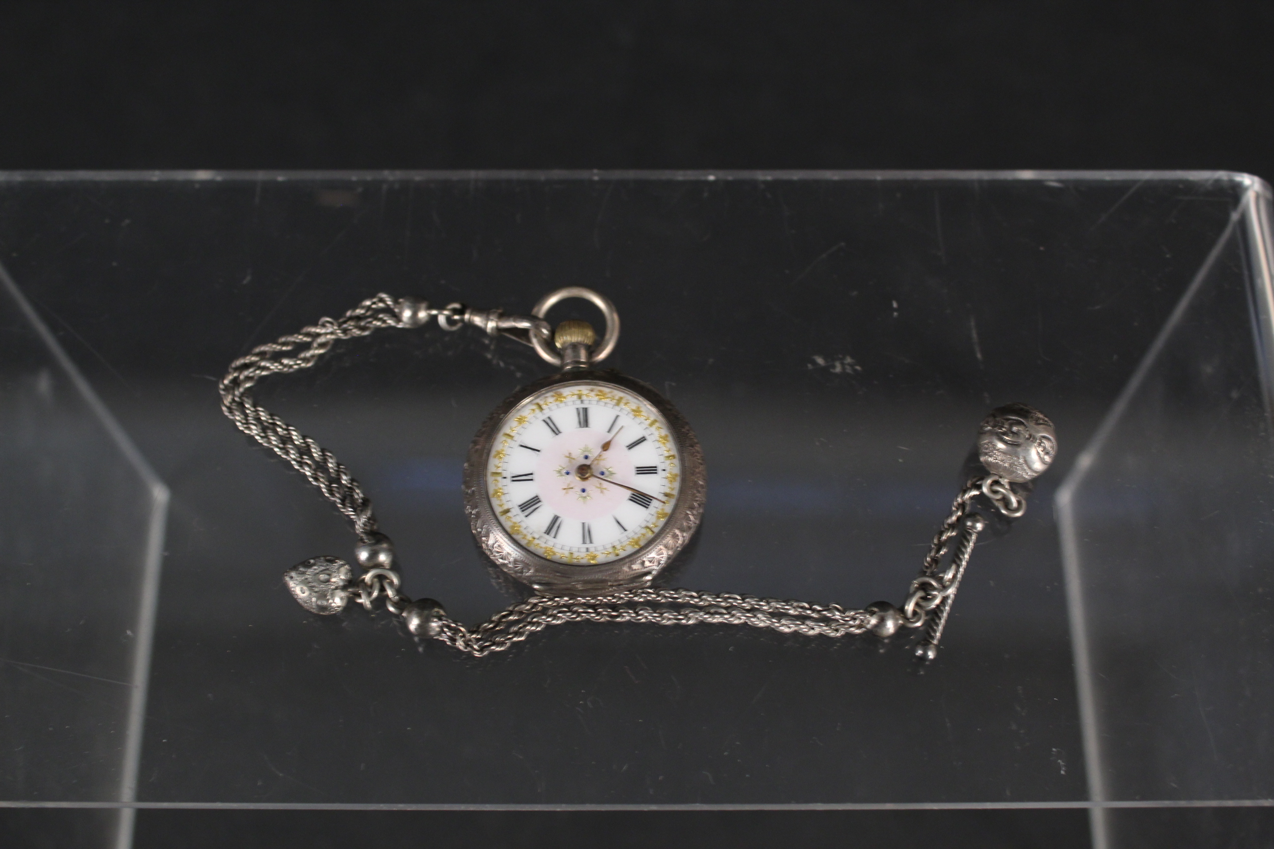 A continental lady's silver fob watch (lacking glass) with a white metal watch chain
