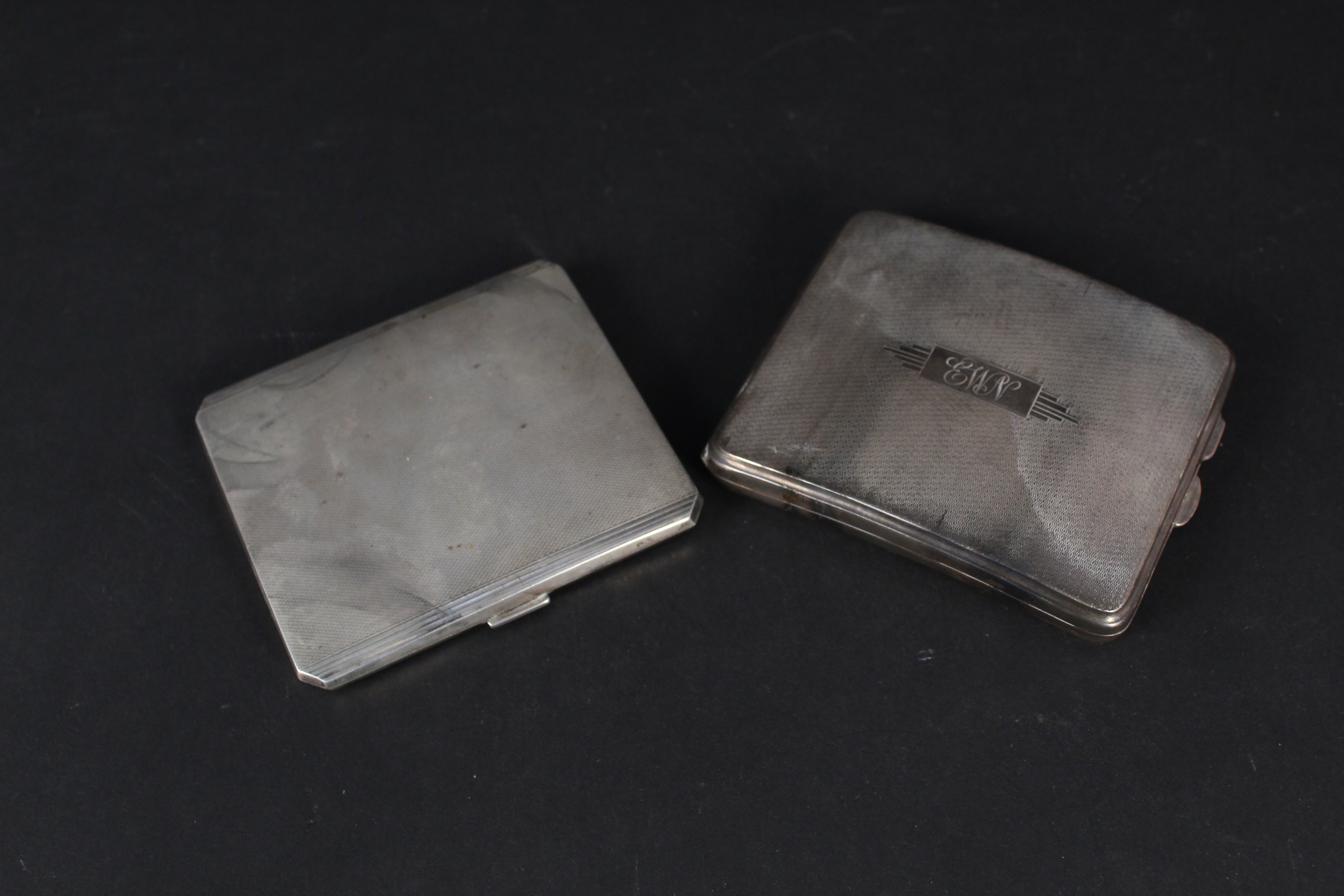 Two Art Deco style silver cigarette cases with engine turned decoration (one with initials