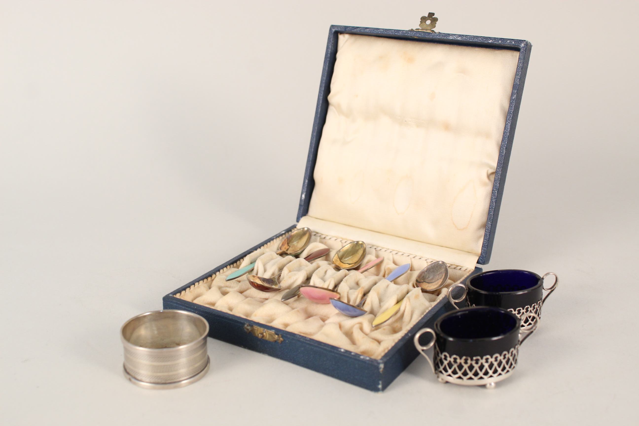 A cased set of six silver enamelled coffee spoons (slight damage to each spoon),