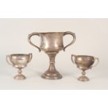 A large silver two handled trophy cup, approx 8" tall plus two smaller examples,