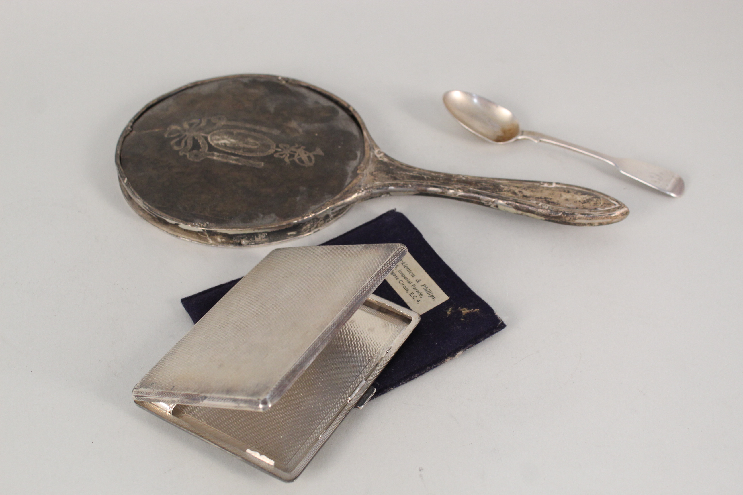 A silver and tortoiseshell hand mirror (as found) together with a silver cigarette case with engine