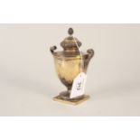 A silver gilt lidded urn with raised and etched decoration of acorn finials,