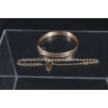 A 9ct gold engraved bangle together with a 9ct gold bracelet with heart shaped padlock clasp,