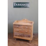 A Victorian four drawer stripped pine dressing chest with upstand