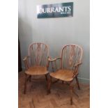 A pair of Edwardian oak wheel back carver chairs