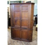 A George III oak four door corner cupboard