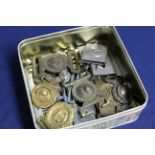 A tin of various military related belt buckles