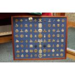 A fine collection of eighty eight British military badges mounded and framed,