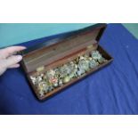 An antique box containing various military badges and buttons