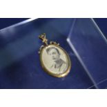 A Victorian 9ct gold locket containing a photograph of a young soldier