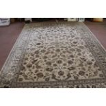 A wool carpet, beige ground within a floral border in blue and brown shades,
