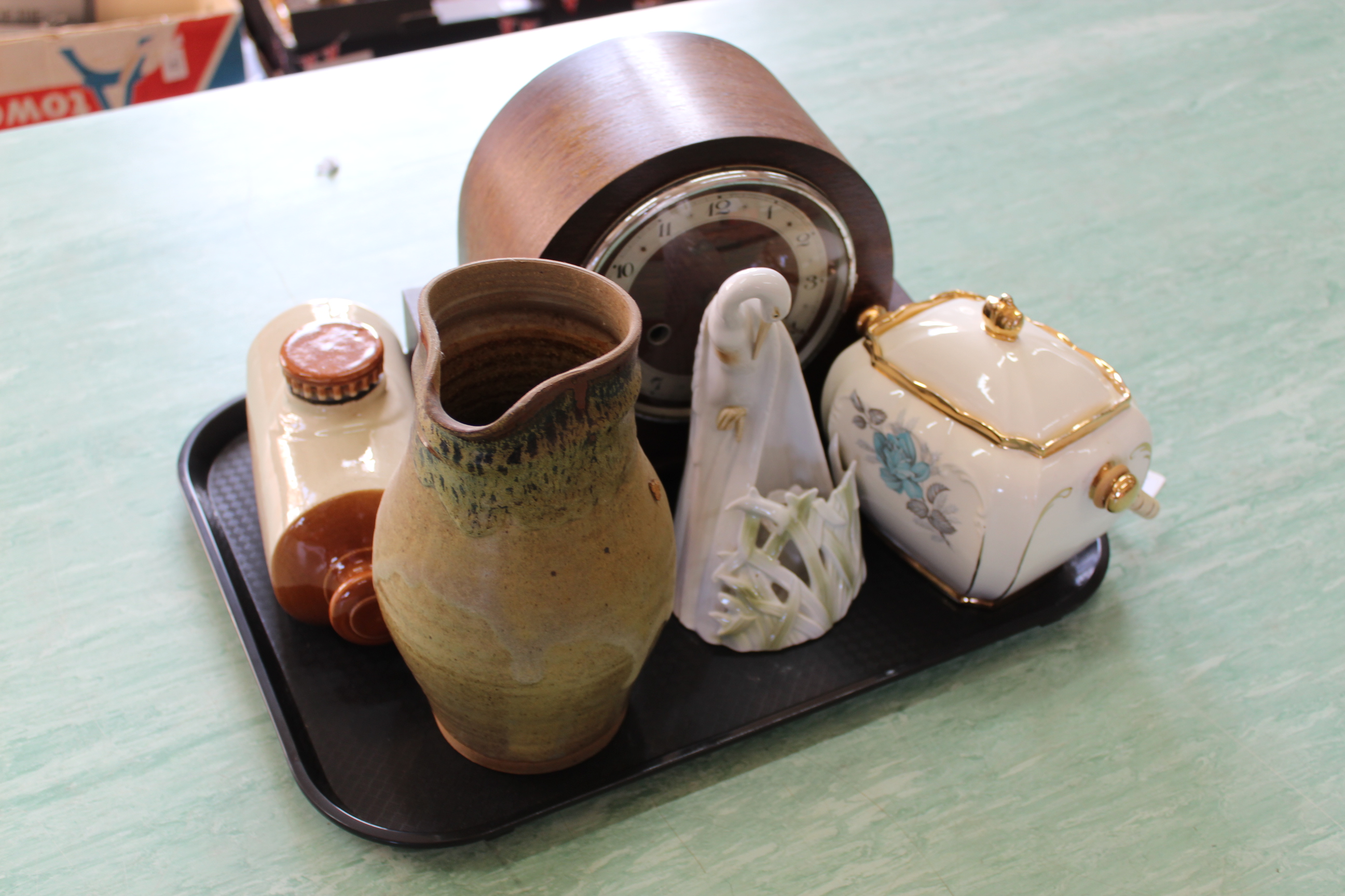 An oak cased striking mantel clock, stoneware hot water bottle, stoneware jug,