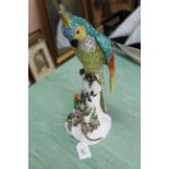 A 19th Century Dresden marked macaw parrot perching on a branch with a mouse at his feet (as found)