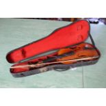 An antique violin in case (distressed and unstrung)