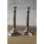 A pair of 18th Century Paktong candlesticks with fluted columns and gadrooned square bases,