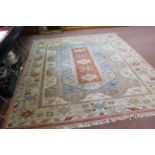 A Turkish wool rug in blue, cream and terracotta shades,