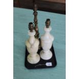 A pair of alabaster style lamp bases together with a brass lamp