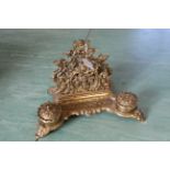 An ornate vintage double brass ink stand, marked "Brevettato" to base, decorated with cherubs,