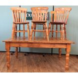 A Victorian style pine kitchen table with six 19th Century beech and elm dining chairs,
